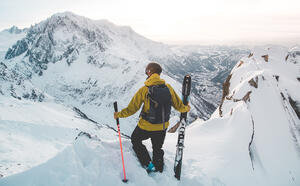 Skieur hors piste qui observe les montagnes enneigées