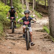Enfant et son père en VTT sur un chemin en forêt