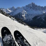 Gros plan sur le bout des skis d'un skieur avec la montagne enneigée en arrière plan
