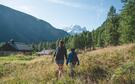 Une femme et un enfant marchent dans une prairie de la vallée